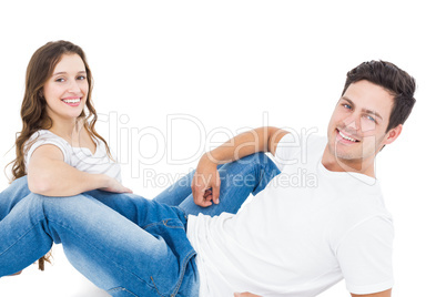 Happy couple lying on the floor looking at the camera