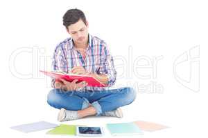 Man reading a book while sitting on the floor