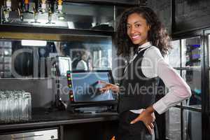 Happy barmaid preparing a bill