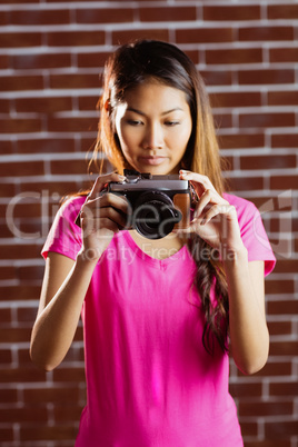 Smiling asian woman taking picture with camera