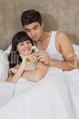 Man offering a flower to woman