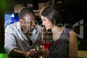 Couple looking at each other and smiling while having drinks