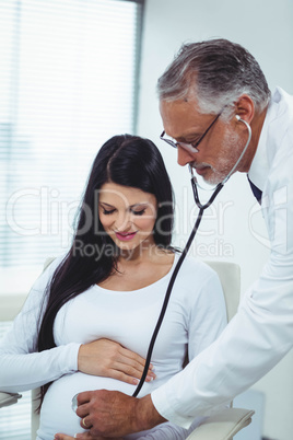 Doctor examining pregnant woman with a stethoscope