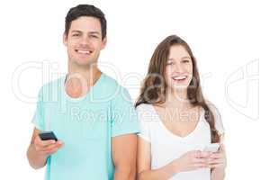 Smiling couple using their smartphones