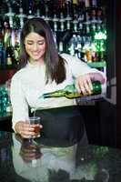 Pretty bartender pouring whiskey in a glass