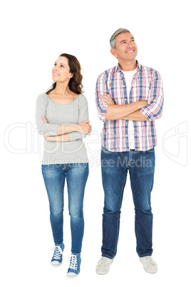 Smiling couple with crossed arms looking away