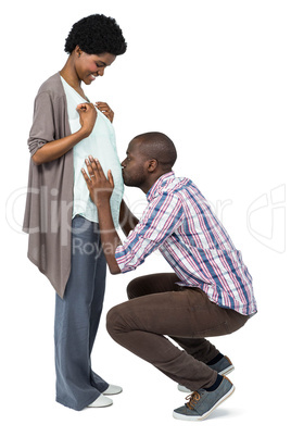 Man kissing the belly of pregnant woman