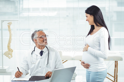 Pregnant woman interacting with doctor at clinic