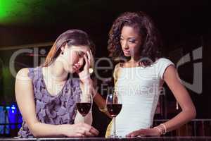 Woman having drinks and comforting her depressed friend