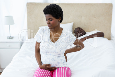 Pregnant woman sitting on bed