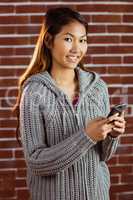 Smiling asian woman using smartphone