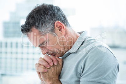 Tensed man standing against window