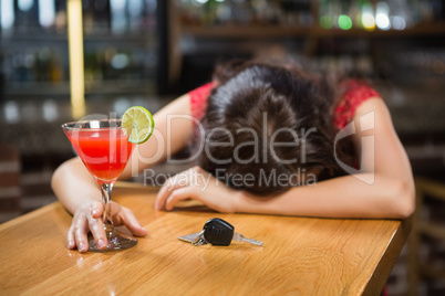 Drunk woman driver leaning on counter with her cocktail