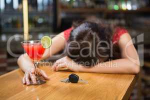 Drunk woman driver leaning on counter with her cocktail