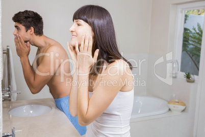 Young couple looking at face in mirror