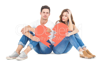 Young couple sitting on floor with broken heart