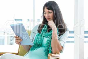 Pregnant woman using digital tablet