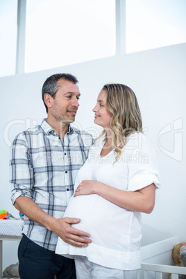 Pregnant couple standing at home