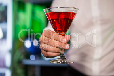 Bartender serving a red martini