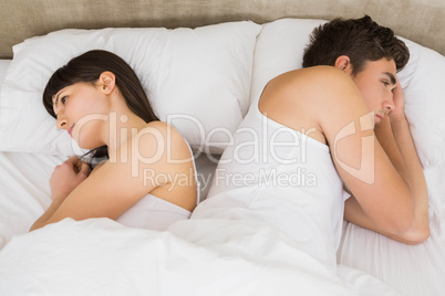 Couple sleeping back to back after an argument