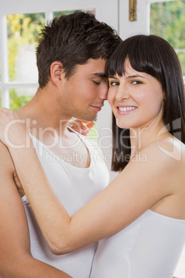 Young couple cuddling on living room