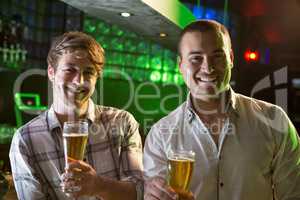 Portrait of two men having beer at bar