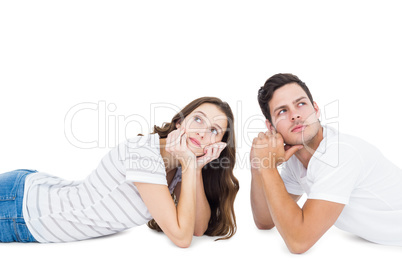 Happy couple lying on the floor looking away