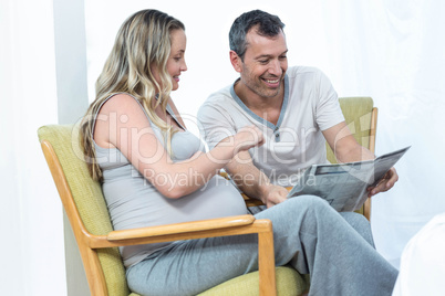 Expecting couple sitting on chair