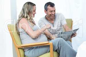 Expecting couple sitting on chair