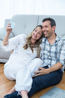 Pregnant couple sitting floor