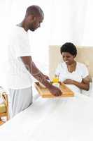 Man serving breakfast to pregnant woman