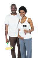Pregnant couple holding roller paint and paint brush