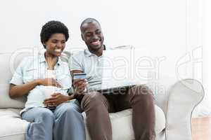 Pregnant couple shopping online on laptop