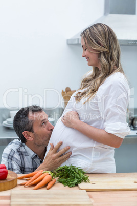 Man kissing the belly of pregnant woman