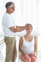 Pregnant woman receiving a head massage from masseur