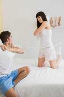 Young couple playing pillow fight