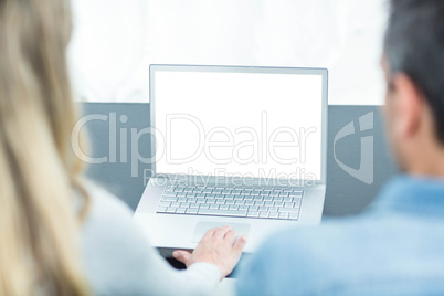 Couple using laptop in living room