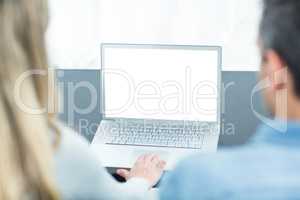 Couple using laptop in living room