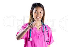 Asian nurse with stethoscope pointing in front of her