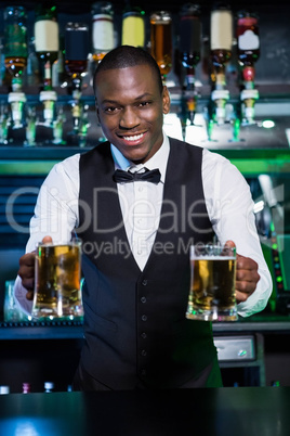 Bartender serving two glasses of beer