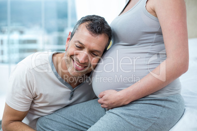 Man listening the belly of pregnant woman