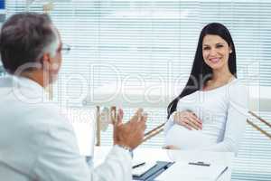 Pregnant woman interacting with doctor at clinic