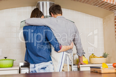 Couple embracing while preparing a meal