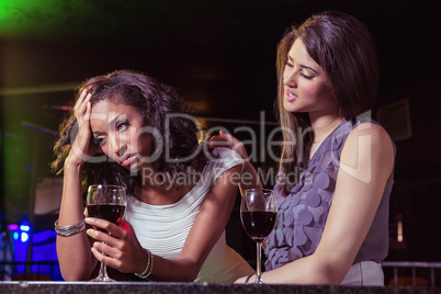 Woman having drinks and comforting her depressed friend