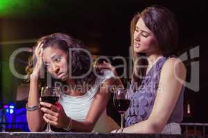 Woman having drinks and comforting her depressed friend