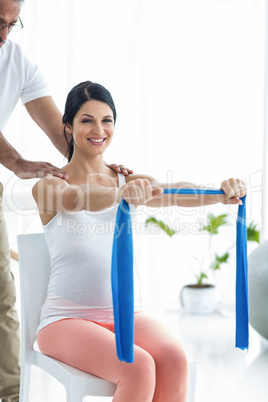 Doctor giving physiotherapy to pregnant woman