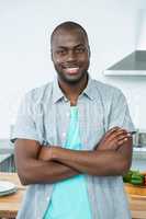 Man standing with arms crossed in kitchen