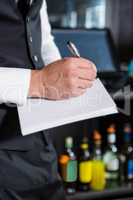 Bartender writing down an order