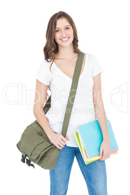 Portrait of happy female college student holding books and shoul