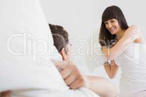 Young couple playing pillow fight